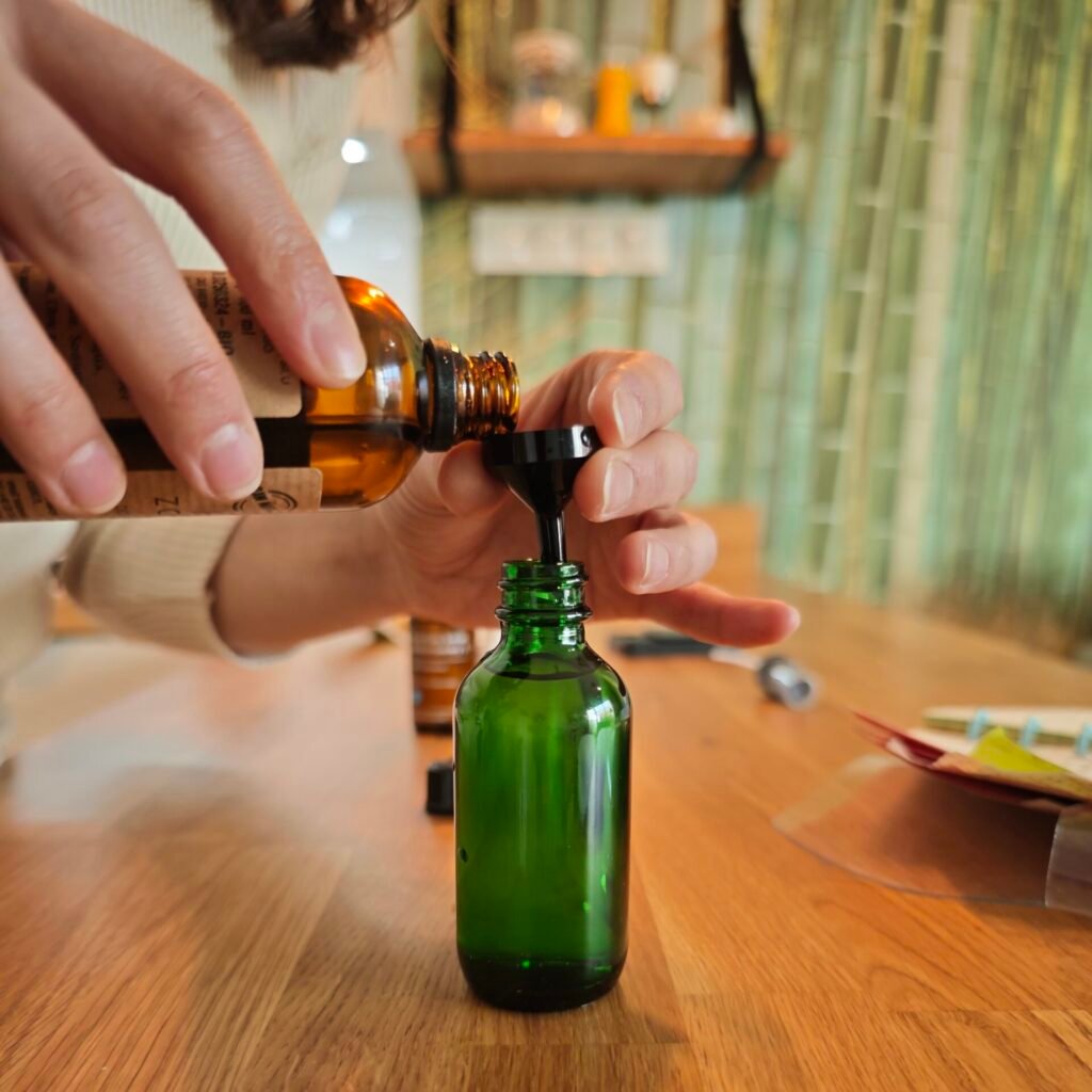 tworzenie esencji z hydrolatu i substancji aktywnych nalewanie hydrolatu do butelki z ciemnego szkła