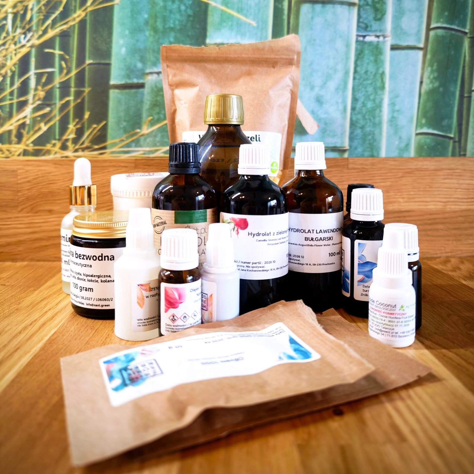 Naturalne surowce kosmetyczne w szklanych buteleczkach i słoikach ustawione na kuchennym blacie