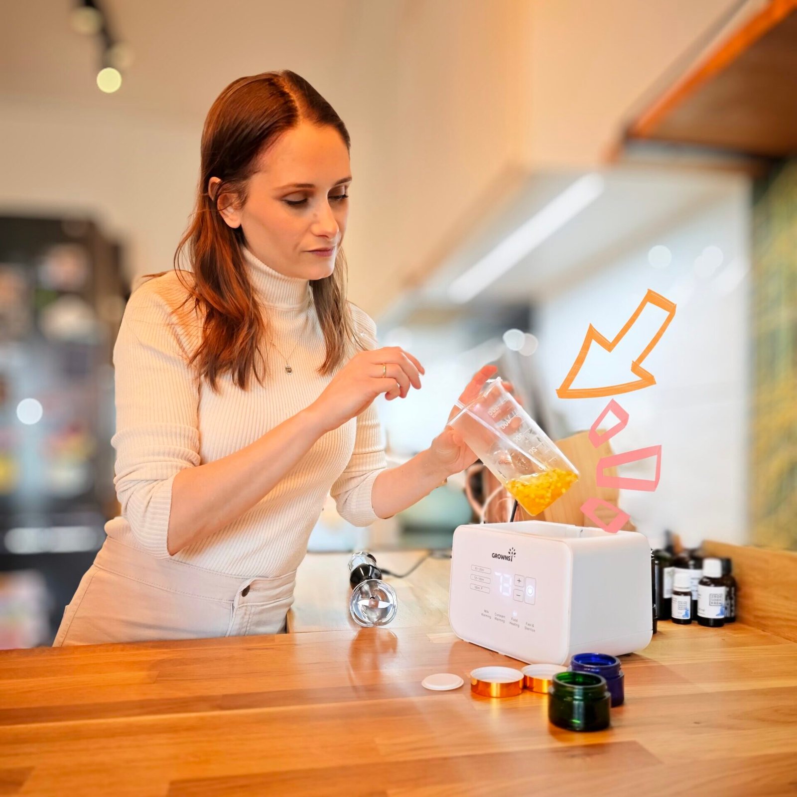 młoda szatynka w skupieniu przygotowuje domowy krem do twarzy z naturalnych składników ustawionych na blacie kuchennym